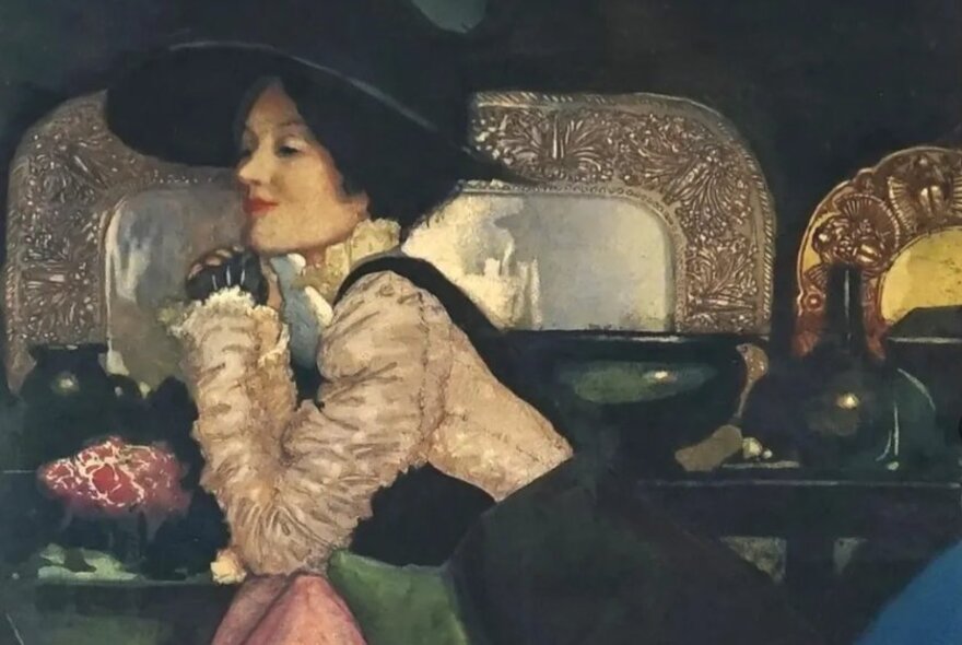 Edwardian painting of a woman wearing a silk blouse and large hat, leaning on a table with artefacts and flowers.