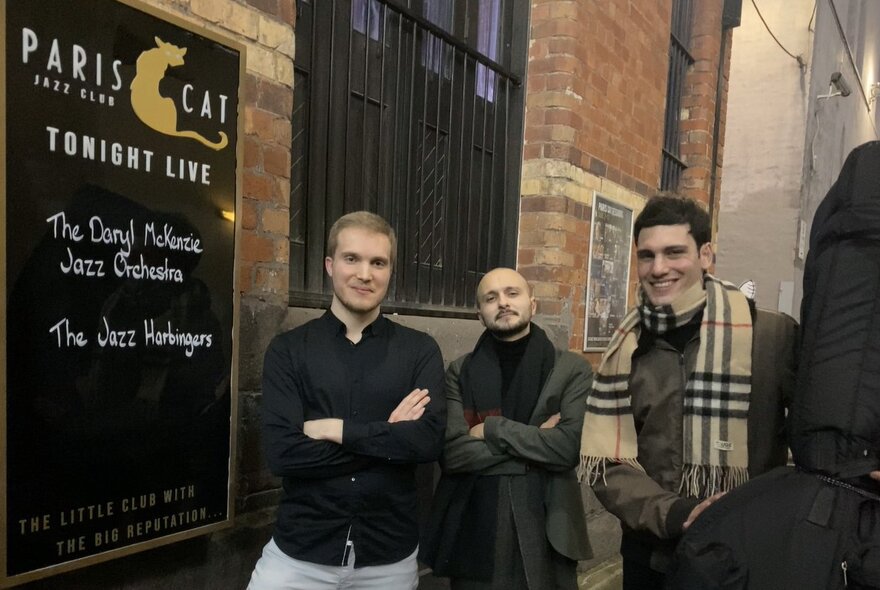 Three musicians posing outside Paris Cat.