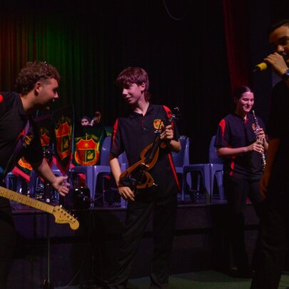 Young musicians and singers performing on stage.