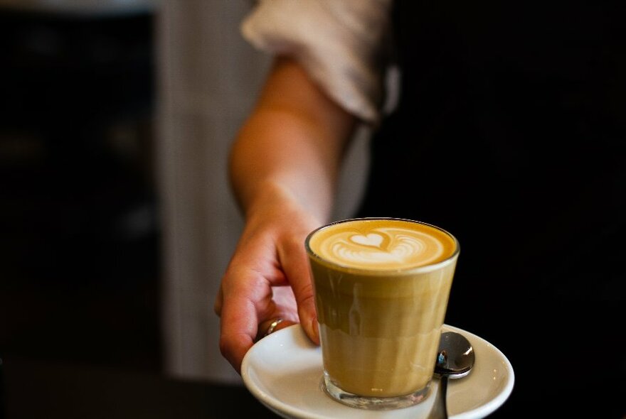 Waitstaff serving a latte.