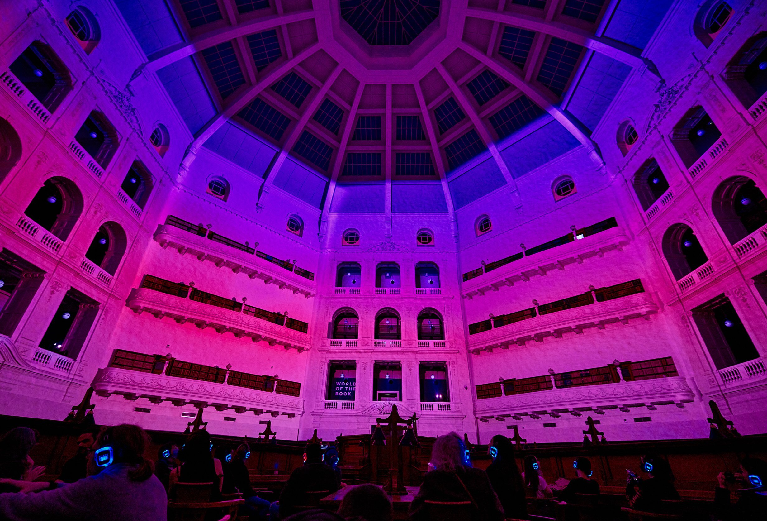 The State Library dome lit up in pink and purple lights at night