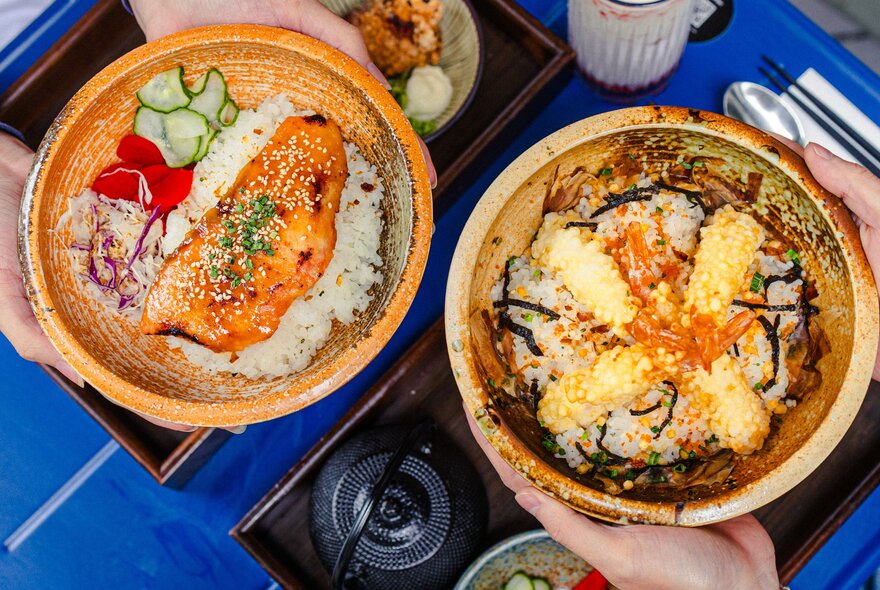 Looking down at salmon and tempura donburi rice bowls from Kome Eatery.