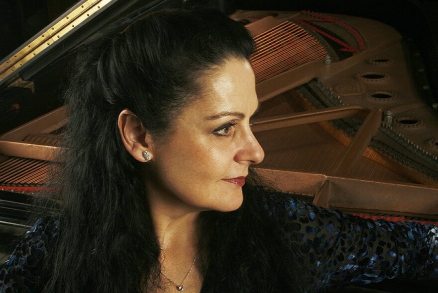 Pianist Sarah Grunstein, a grand piano in the background.