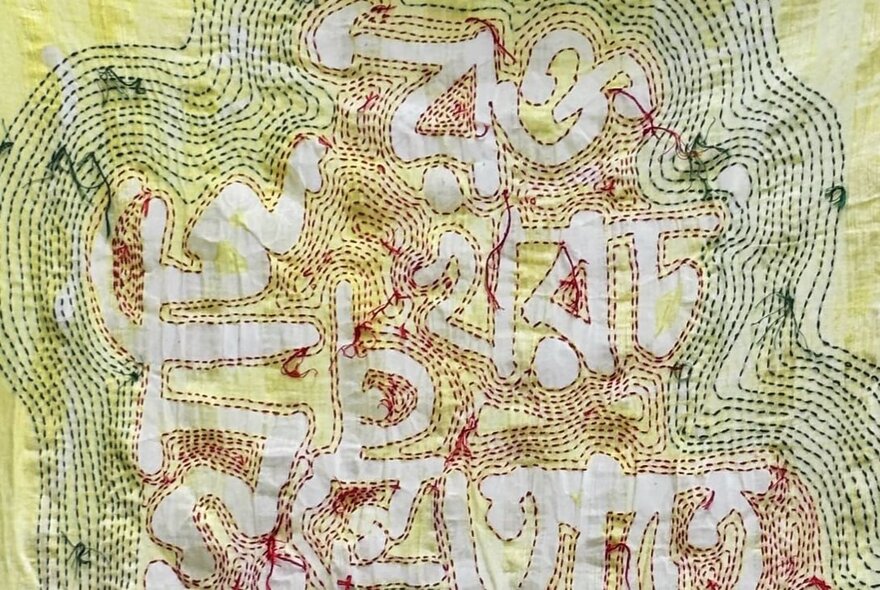 Artwork from artist, Mita Chowdhury showing elaborate hand-stitching on a Bangladeshi handloom Khadi and an old sari, using a found gum tree branch and cotton threads.