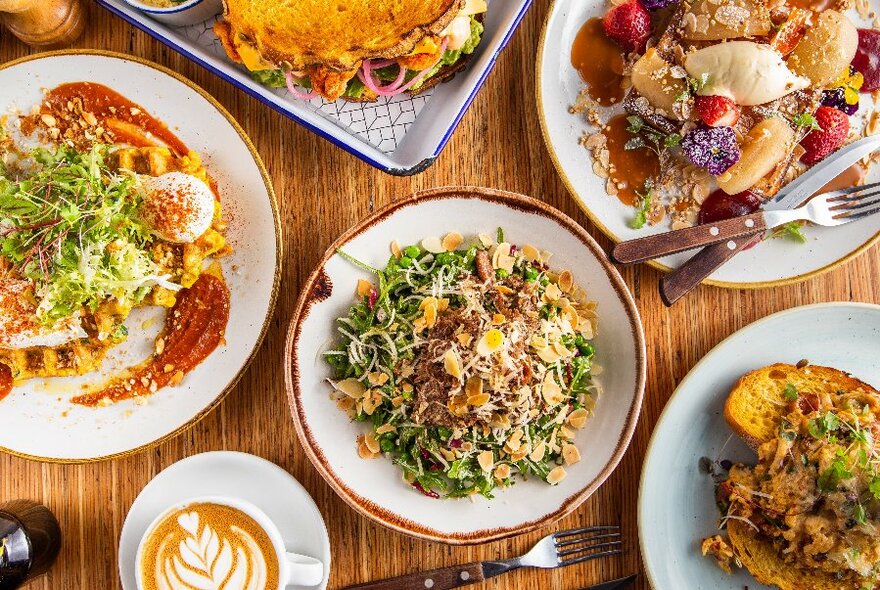 Various brunch dishes and a coffee, viewed from above.