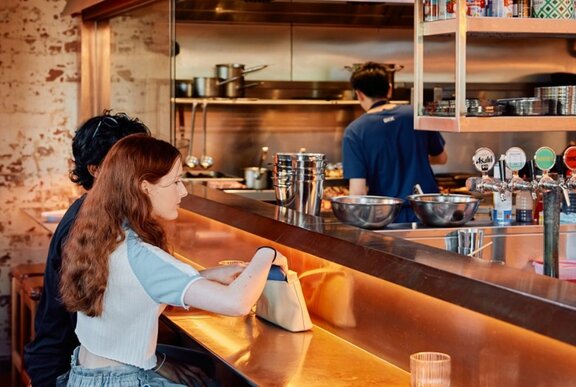 Two people sitting at a bar counter.