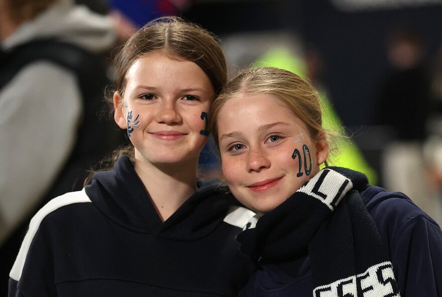 Two young girls in AFW supported gear with stencils on their faces. 