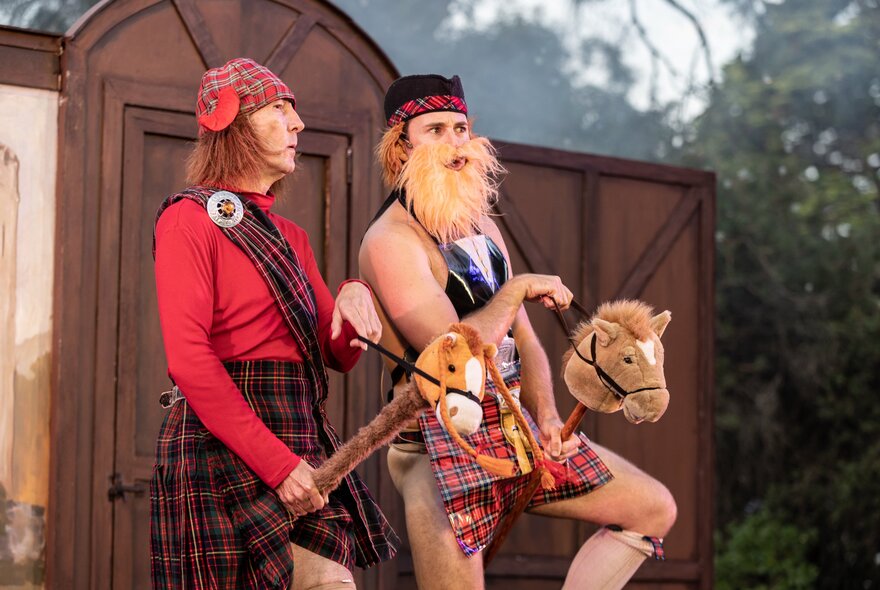 Two performers dressed as Scotsmen riding hobby horses. 