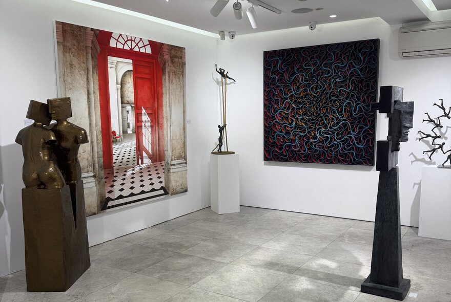 A display of hanging and standing artwork in a gallery setting.