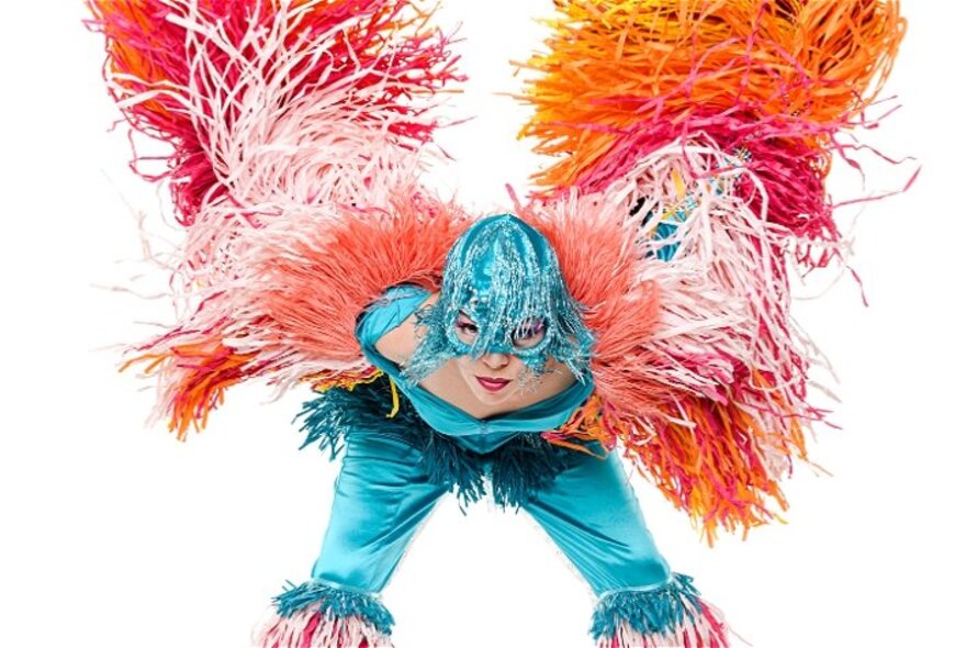 Performer wearing feather wings and blue bird helmet.