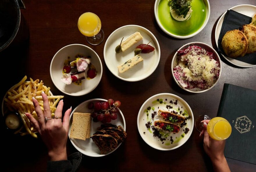 A flatlay of lunch and brunch dishes on a dark wooden table