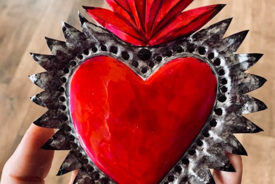 Mexican-inspired tin decoration in the shape of a red heart.