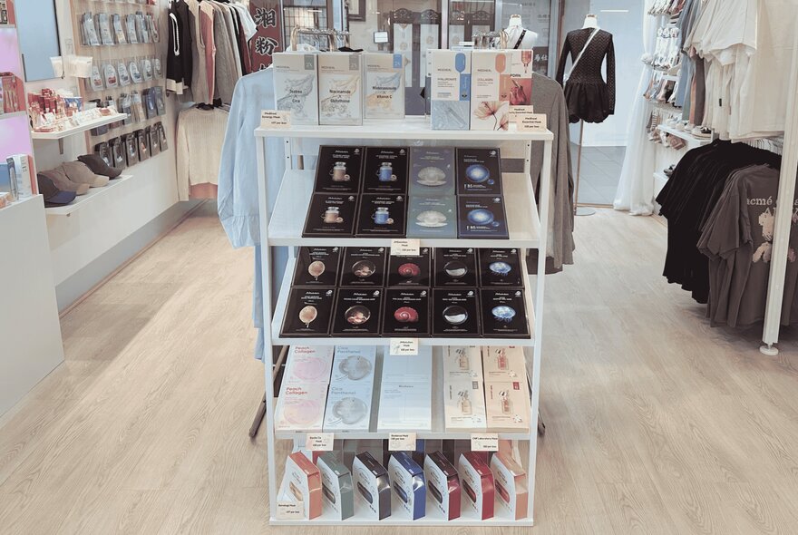 Interior of a shop with display racks of clothes and shelves of cosmetics, accessories and products for sale.
