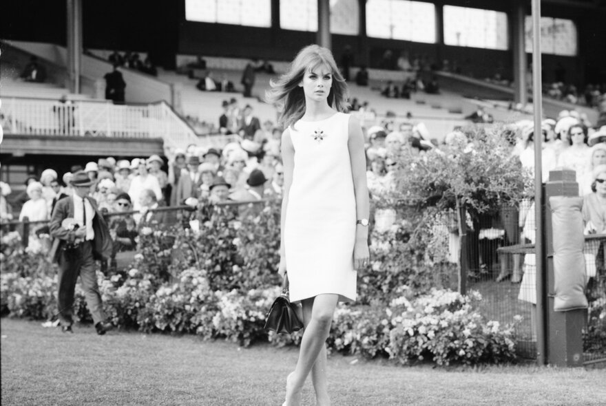 Black and white photograph from the 1960s of model, Twiggy, wearing a mini-dress at the Melbourne Cup.