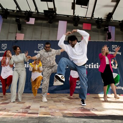 People dancing on stage at an Indian festival.