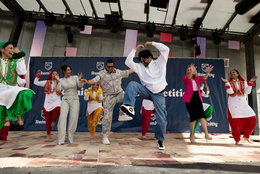 People dancing on stage at an Indian festival.
