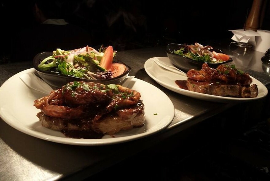 A selection of meat dishes accompanied by vegetables in separate bowls.