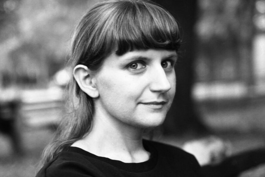 Black and white portrait of author, Liz Pelly, looking sideways at the camera with a slight smile.