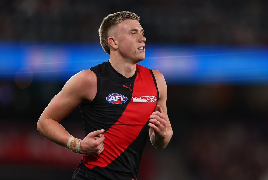 An Essendon Bombers AFL player running during a game.