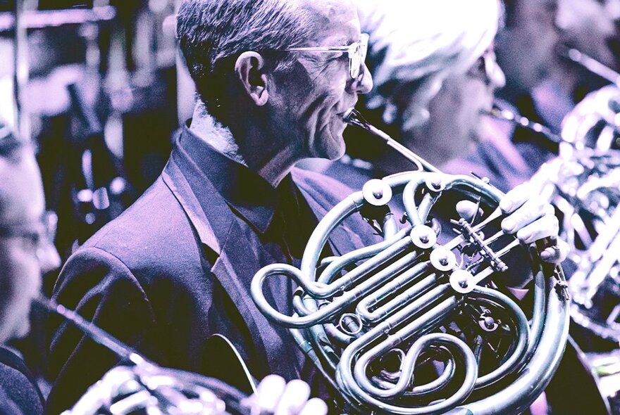 Sepia image of brass musicians performing on stage.