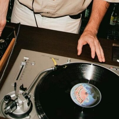 DJ at a turntable with a record playing.