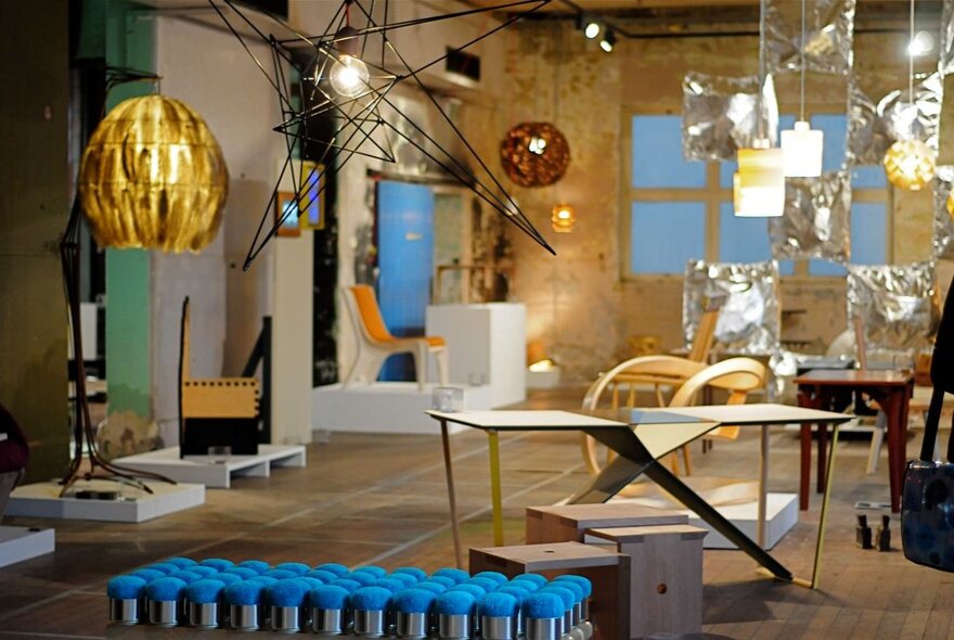 An exhibition space showing lots of light fittings, lamps, desks and ornaments. 