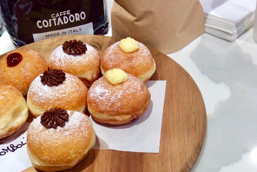 A wooden platter of donuts.