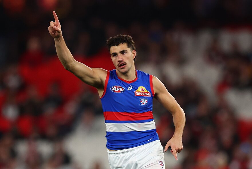 Western Bulldogs AFL football player with arms outstretched during a match.
