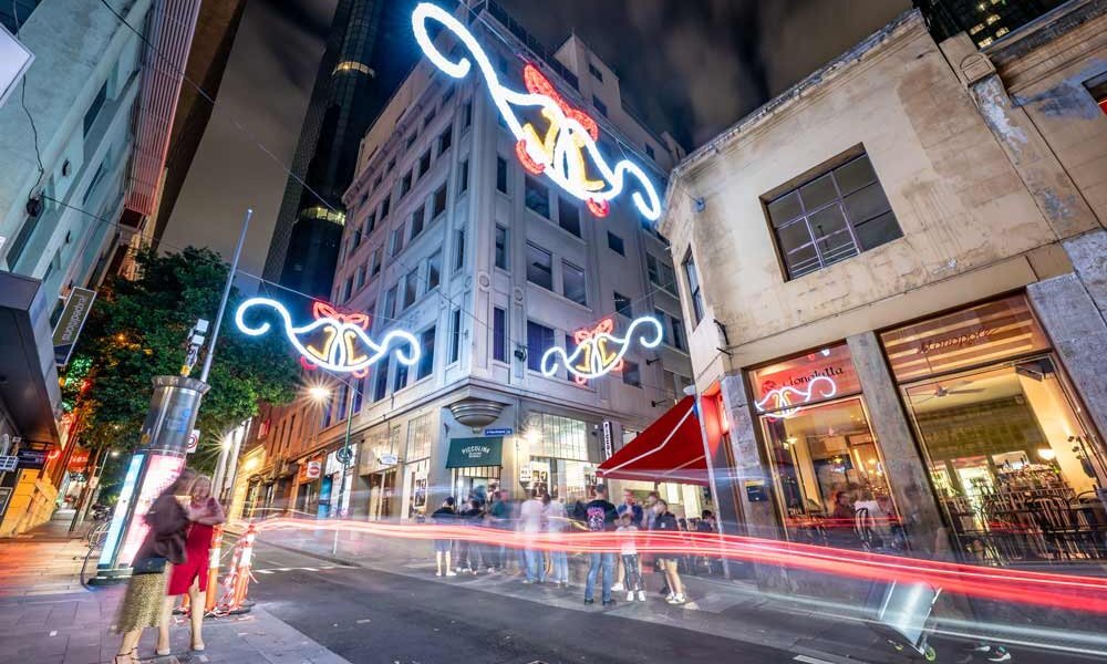 A city laneway with glowing decorations lit up at night