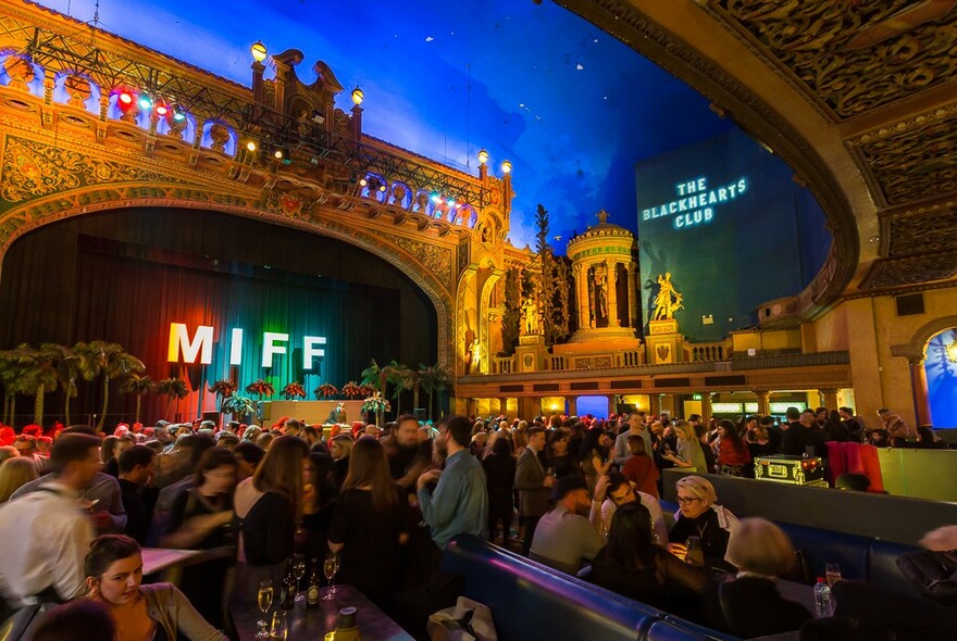 A crowd of people mingling inside Forum Melbourne. 