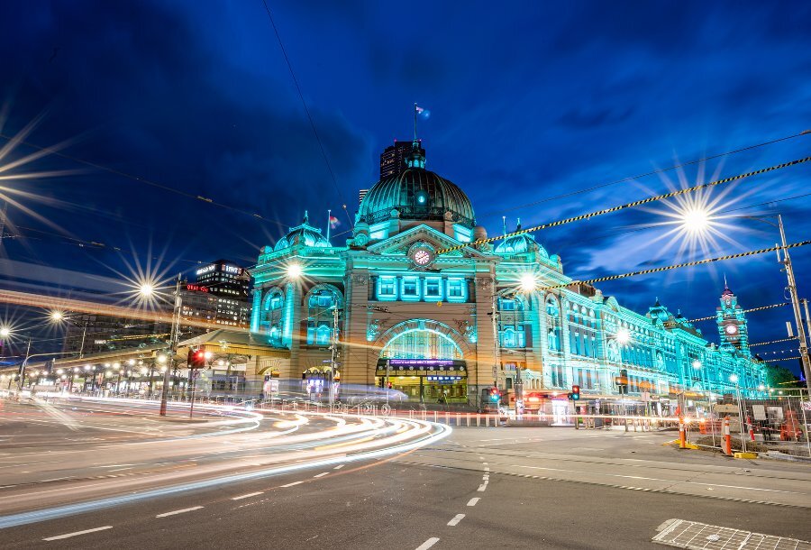 Flinders Street Station illuminated blue at night.