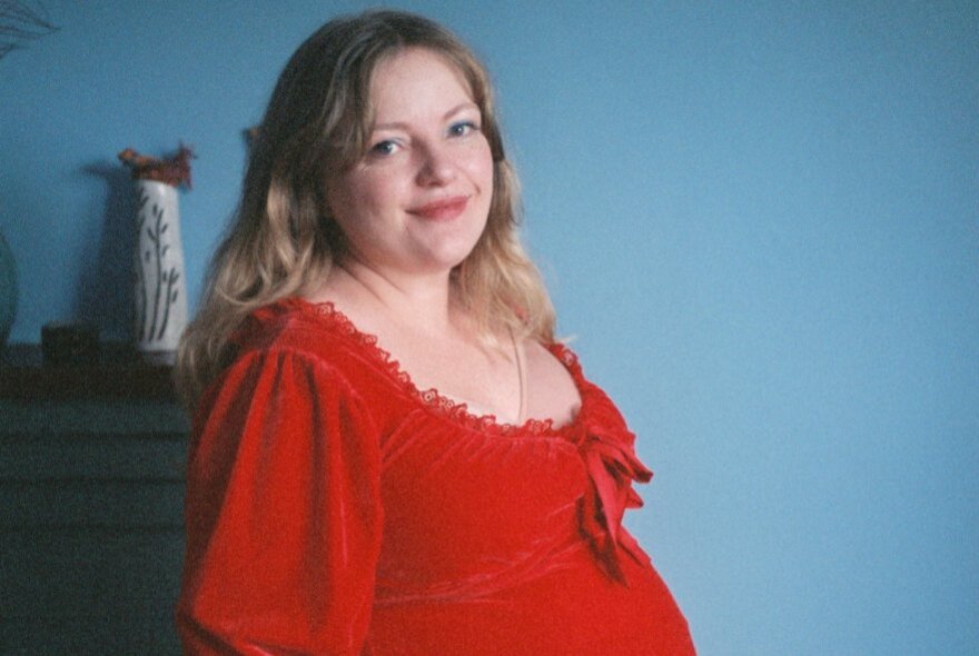 Blonde woman wearing a low-cut red flounced dress.