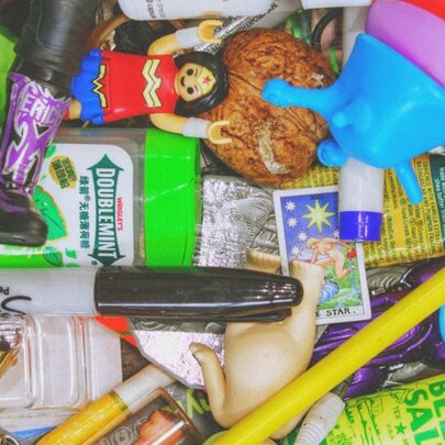 Top down view of a jumble of small miscellaneous items, including miniature toys, a marker, and small plastic figurines.