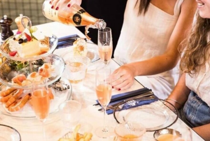 People enjoying sparkiling wine and a seafood high tea.