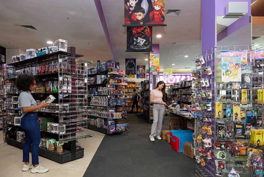 People browsing products in a pop culture comic book store.