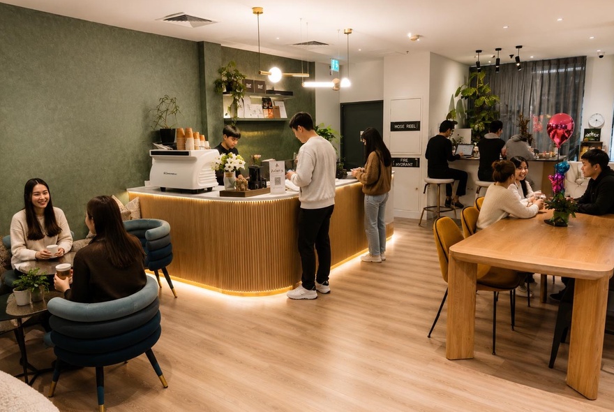 People in a small cafe, some seated and some at the counter.