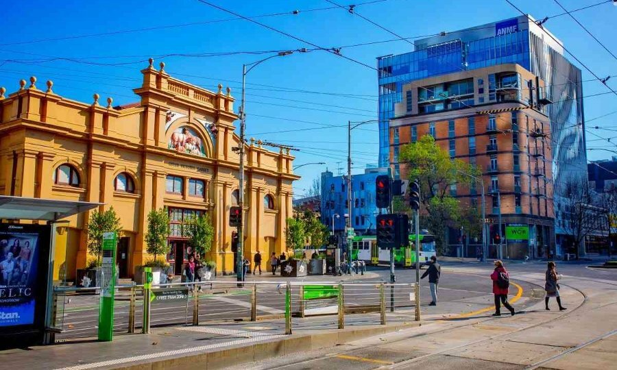 A large yellow market building outside some tram lines