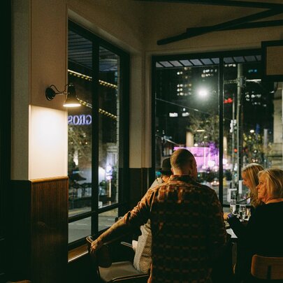 Patrons enjoying the atmosphere at a city pub at night.
