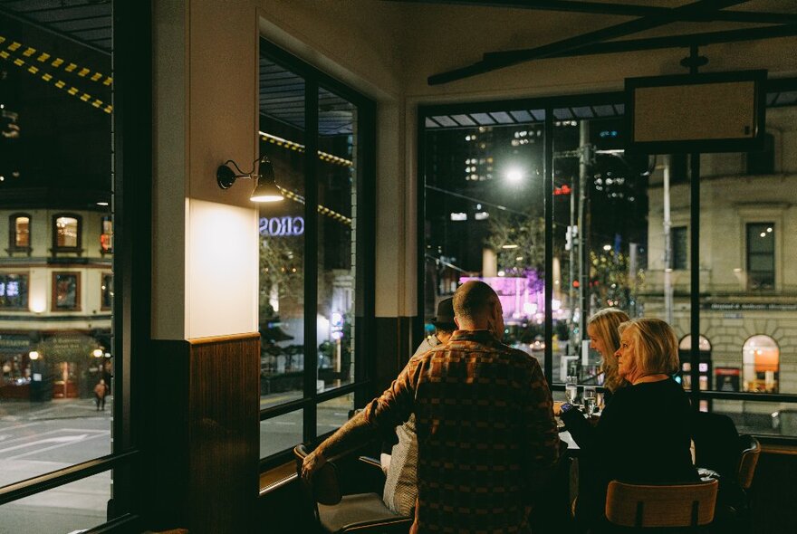 Patrons enjoying the atmosphere at a city pub at night.