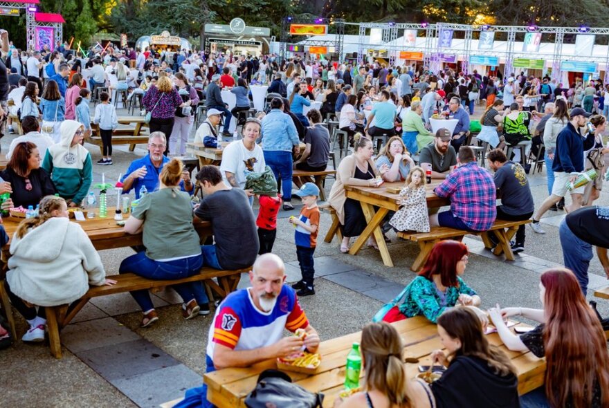 A vast space with a crowd of people at various tables dining.