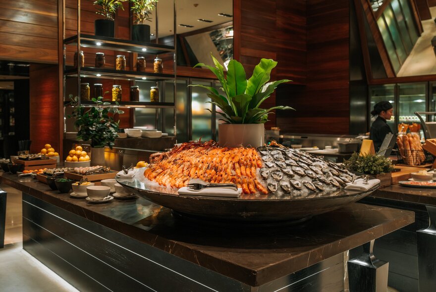 Seafood buffet station with iced mound of prawns and oysters.