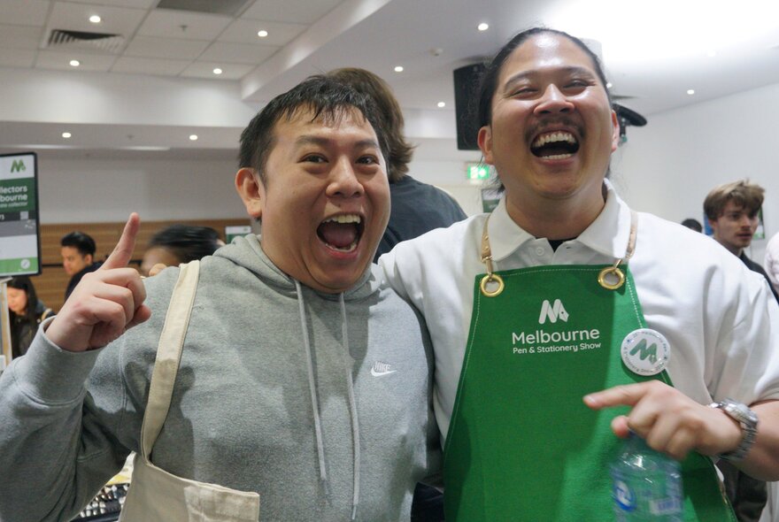 Two excited people smiling and pointing.