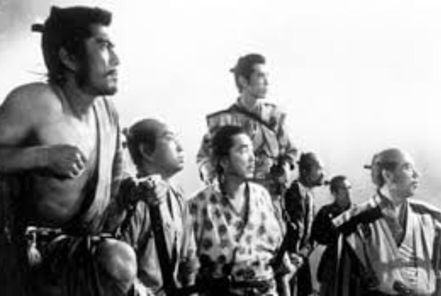 The seven samurai standing in a row, a still  from the movie Seven Samurai; black and white image.