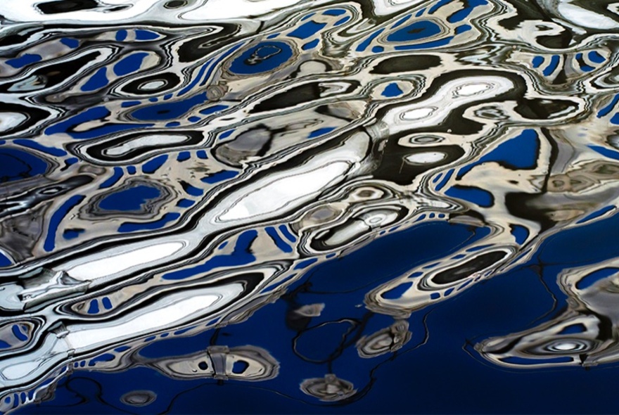 Highly reflective ripples on the surface of water with swirling patterns. 