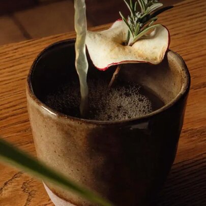 Warmed cocktail with rosemary sprig and steam.