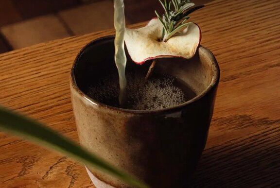 Warmed cocktail with rosemary sprig and steam.