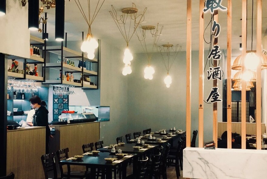 Taketori interior with marble and wood room divider, tables and chairs, bar area.