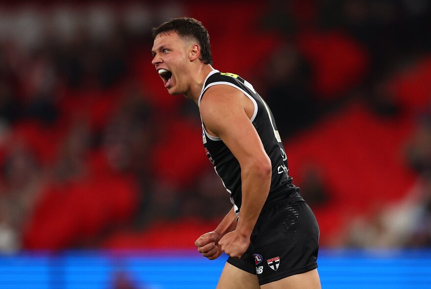 St Kilda AFL football player screaming with fists clenched during a match.