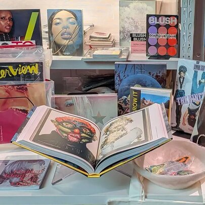 A display table with fashion magazines and books arranged for an exhibition.