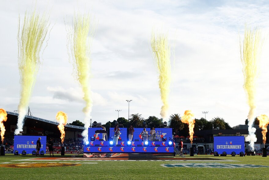 North Melbourne AFLW football team with yellow firework streams.